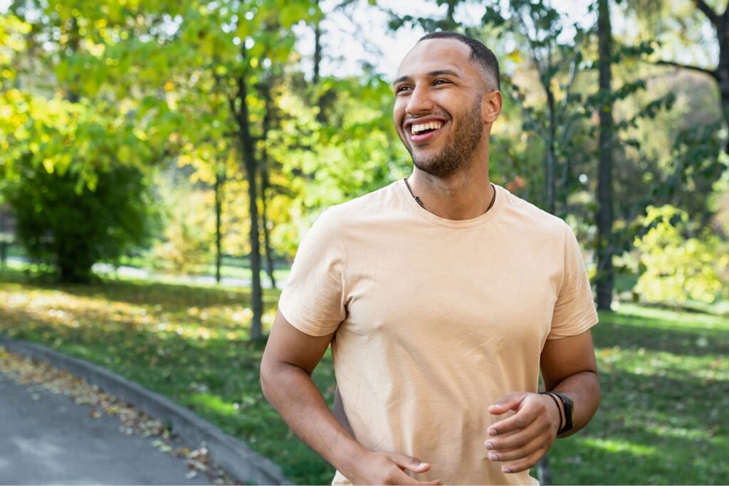 man smiling while running outdoors