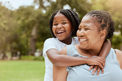 woman and daughter smiling at park